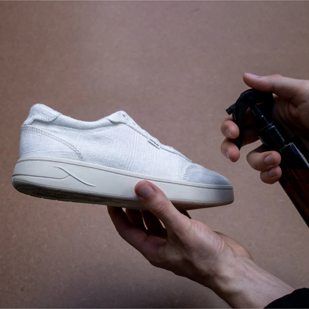 spraying Orba Ghost Off-White Sneaker with stain protector